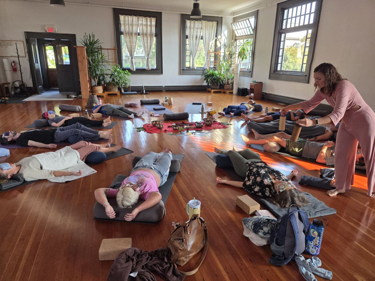 Sound healing with chimes during a group rest on yoga mats